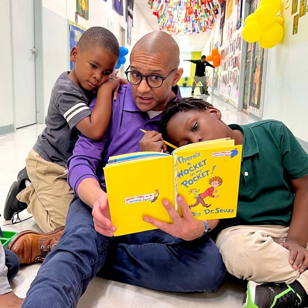 An LPTM mentor reads to two young apprentices